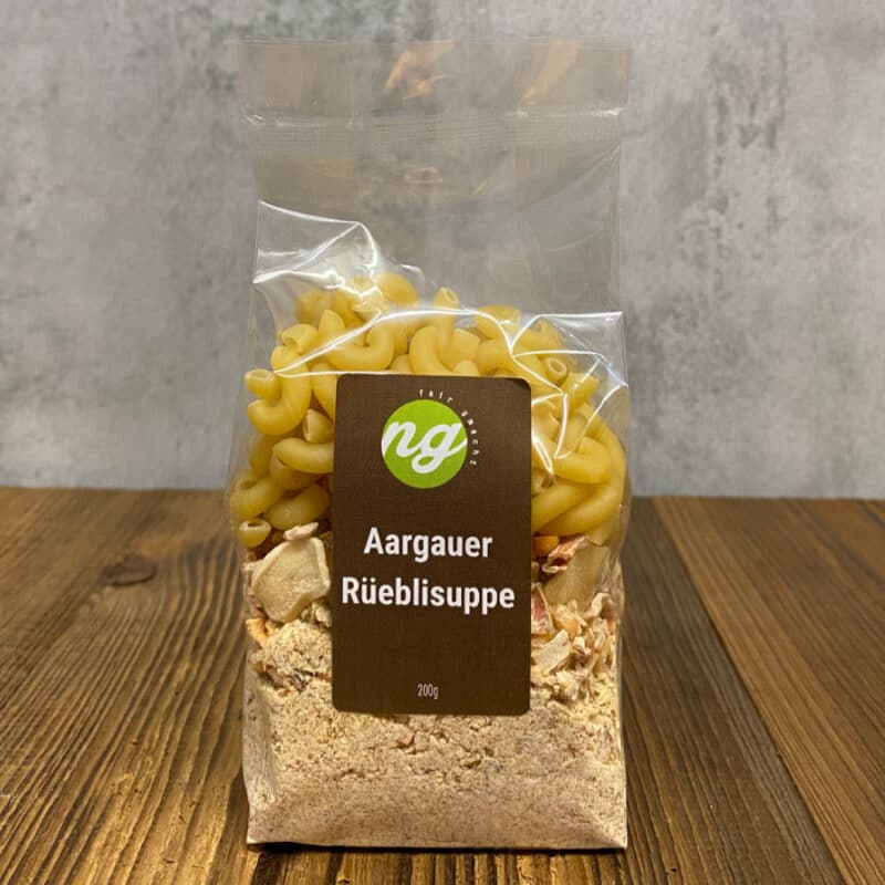 Plastic bag containing Aargauer Rüeblisuppe soup mix with elbow pasta, label shows 'Aargauer Rüeblisuppe' and brand logo on a brown rectangle