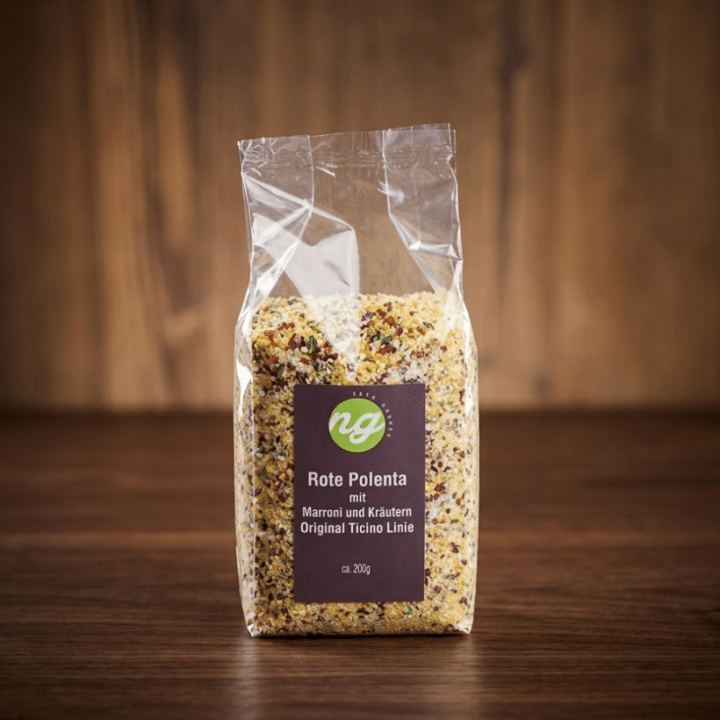 Plastic bag of seasoned red polenta grains with herbs on a wooden surface; label reads 'Rote Polenta mit Marroni und Kräutern, Original Ticino Linie'