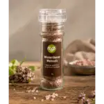Clear glass bottle of pink salt crystals labeled 'Winterthurer Weinsalz' on a wooden table.