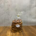 Clear bag of stacked pretzels tied at the top with a twist tie, placed on a wooden table.