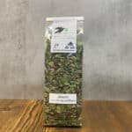 Tall bag of loose herbal tea with green leaves and pink petals, labeled Abendrot 'Lass den Tag ausklingen'.